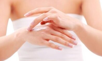 meisje dat zalf op haar hand aanbrengt